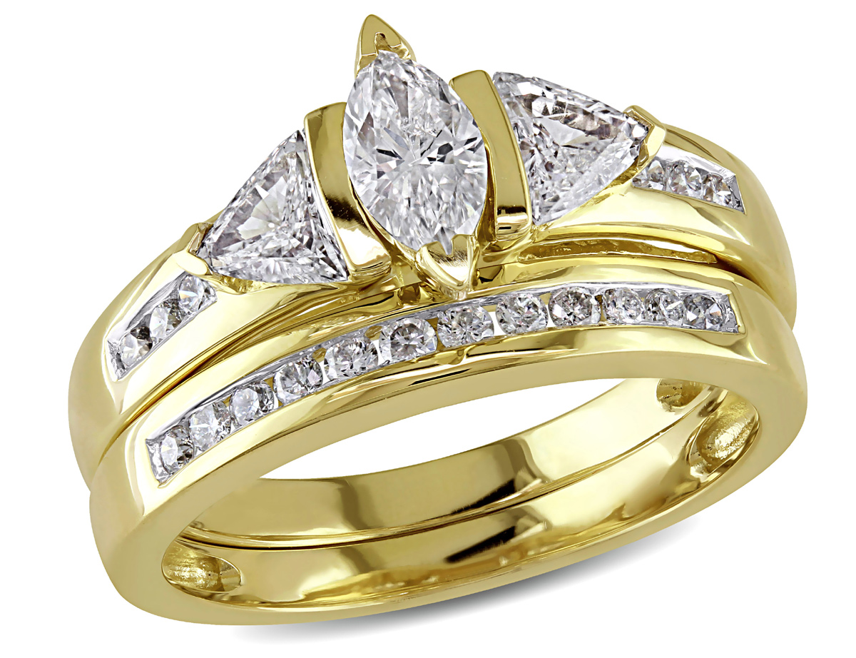 This stunning bridal ring set features a marquise-cut diamond center stone with diamond side stones set in 14 karat yellow gold. Ring glimmer with highly polished finish.