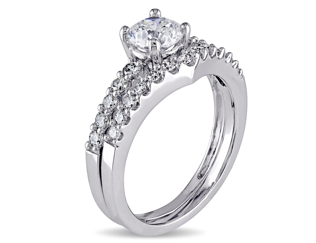 This exquisite bridal ring set features a stunning engagement ring with a contour wedding band set in 14-karat white gold. These gorgeous rings are enhanced with a high polish finish.